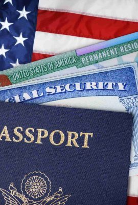 United States passport, social security card and resident card over american flag. Immigration concept