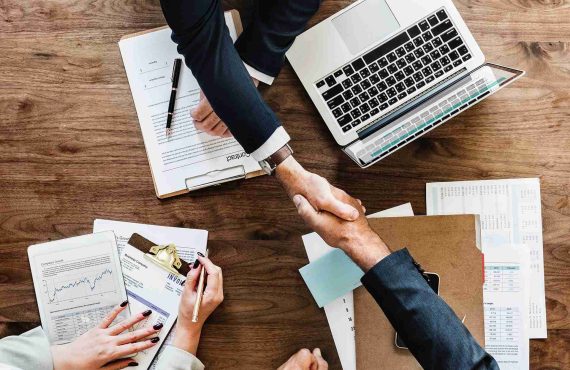 business people signing contract and shaking hands